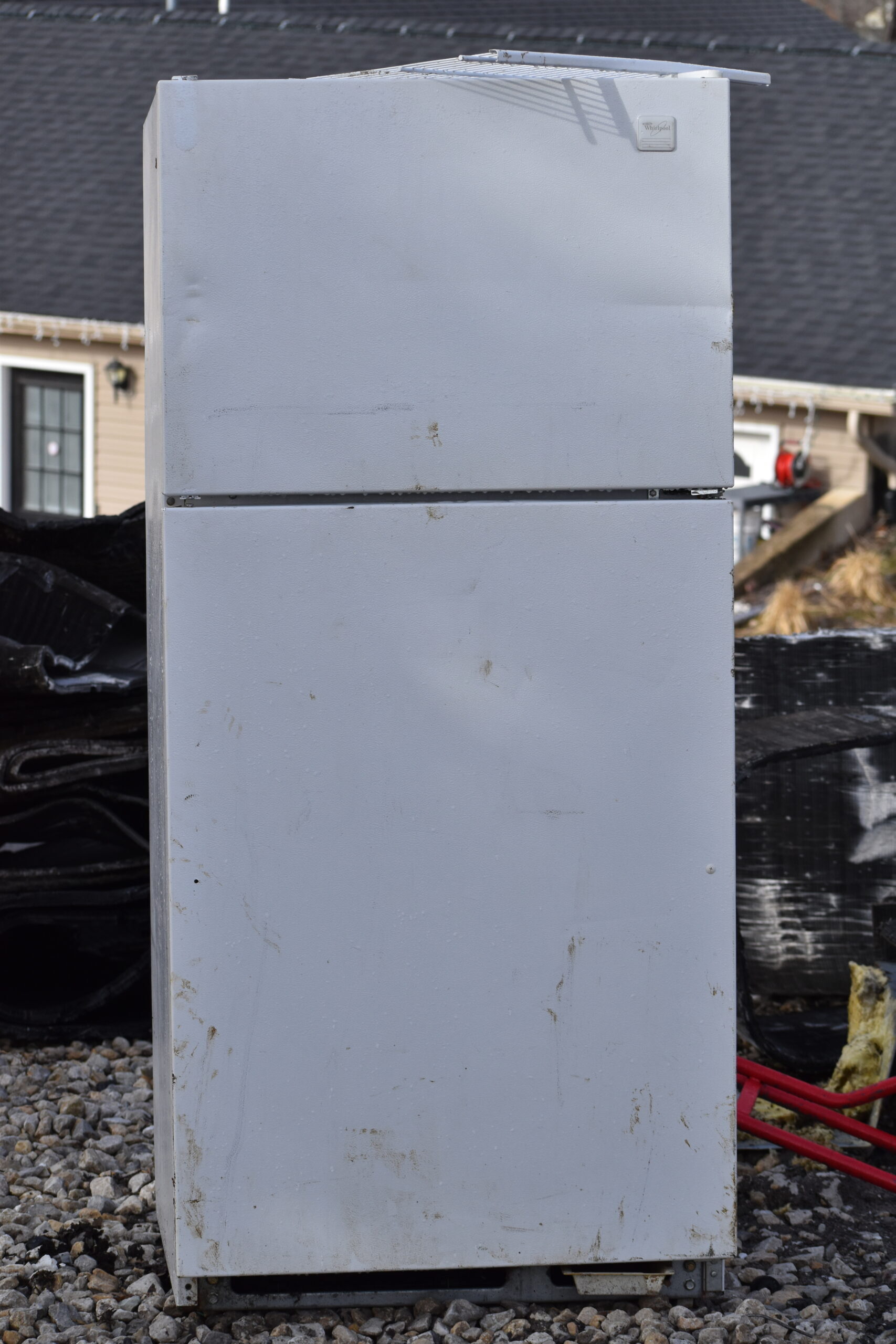 Junk removal team removing an old refrigerator from a home